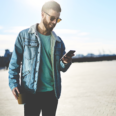 image of man on vacation using phone for mobile banking